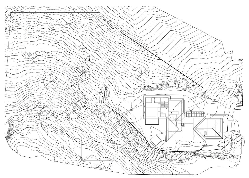 Architectural site plan drawing with topographic contour lines and building floor plan on sloped terrain.